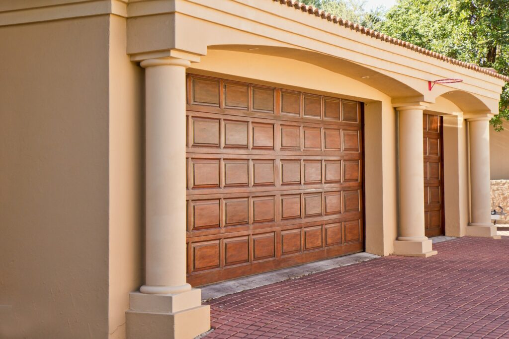 A new, clean wooden garage door on a residential home.